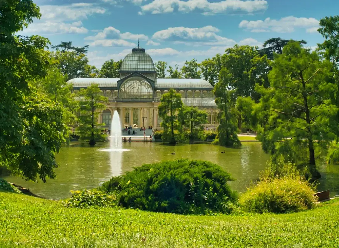 Palacio de Cristal y estanque con fuente en el parque del Retiro, en Madrid