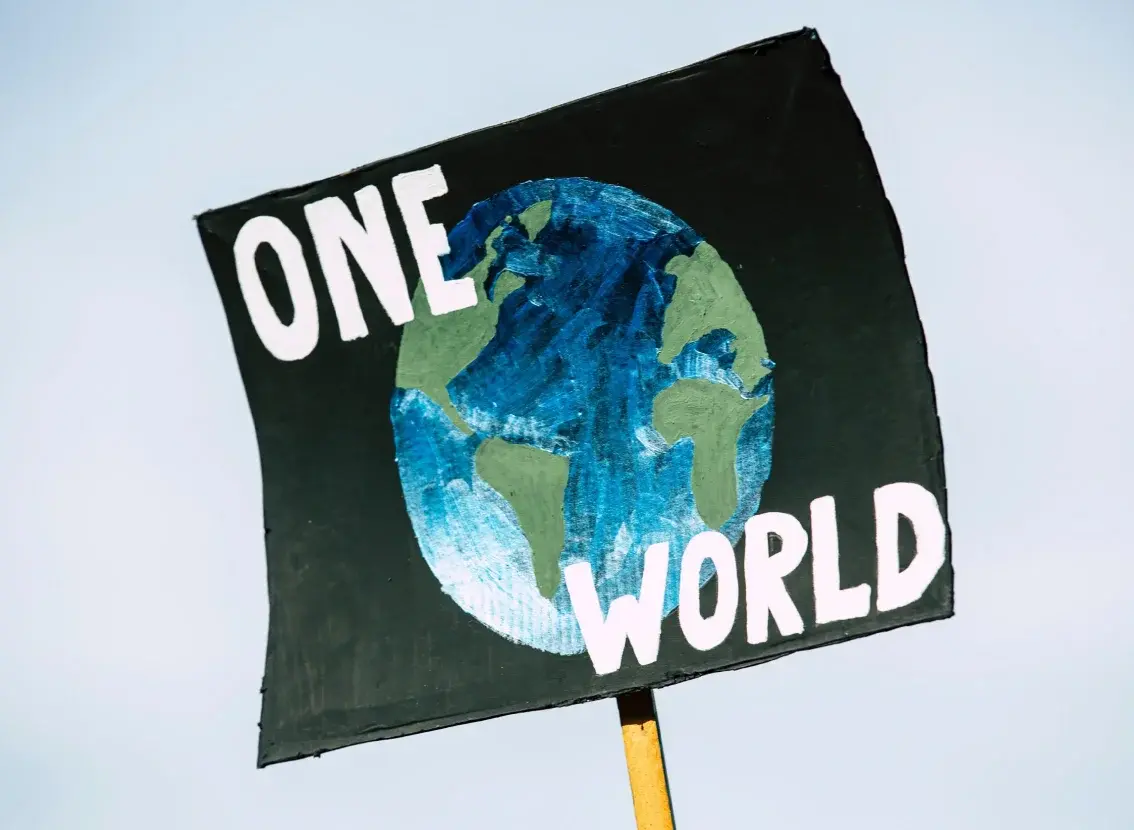 Pancarta con el lema «One World» y un dibujo de la Tierra